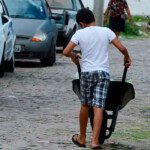 Menino com uma galinhota representando trabalho Infantil