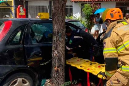 Carro colidido contra árvore no bairro Santo Antônio em Aracaju com viatura dos bombeiros ao lado.