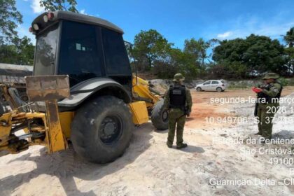 Retroescavadeira usada em extração ilegal de areia sendo apreendida pela CIPAm em São Cristóvão.