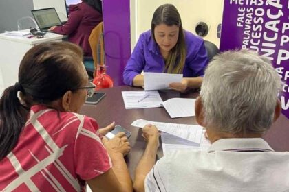 Família analisando contrato de compra de imóvel com maquete de casa sobre a mesa