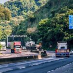 Caminhões trafegando em rodovia representando as novas regras para frete no Brasil da ANTT.