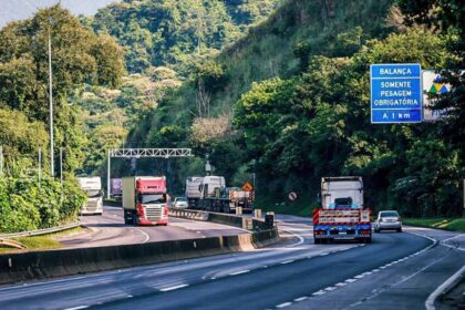 Caminhões trafegando em rodovia representando as novas regras para frete no Brasil da ANTT.