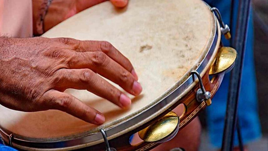 Um pandeiro decorado em primeiro plano, simbolizando o Samba de Terreiro.