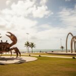 Foto da Orla de Atalaia em Aracaju com céu nublado e mormaço.