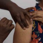 Profissional de saúde aplicando vacina em Unidade Básica de Saúde em Aracaju durante o Dia D