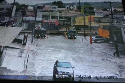 Equipes da Prefeitura de Aracaju monitorando escoamento de canal durante chuva forte.