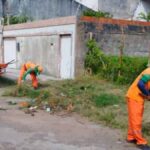 Equipes da Emsurb realizando roçagem e limpeza de canal em bairro de Aracaju.
