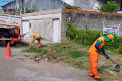 Equipes da Emsurb realizando roçagem e limpeza de canal em bairro de Aracaju.