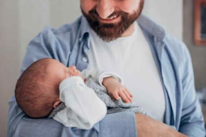 Pai segurando bebê recém-nascido, simbolizando a nova lei de licença-paternidade sancionada em 2026.