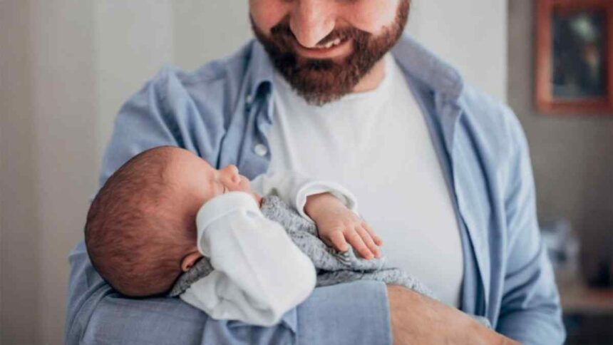 Pai segurando bebê recém-nascido, simbolizando a nova lei de licença-paternidade sancionada em 2026.