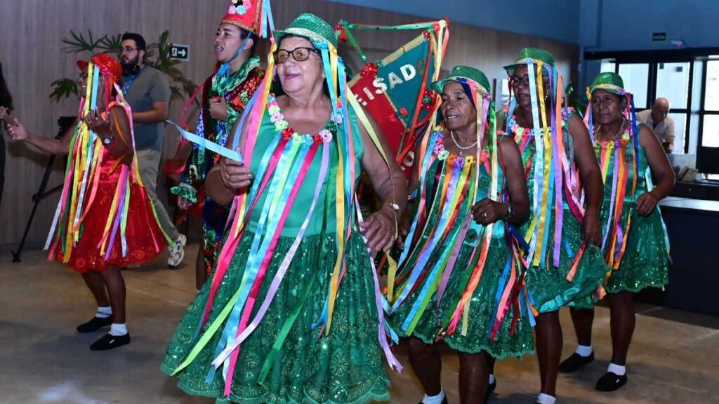 Grupo dançando com trajes coloridos.