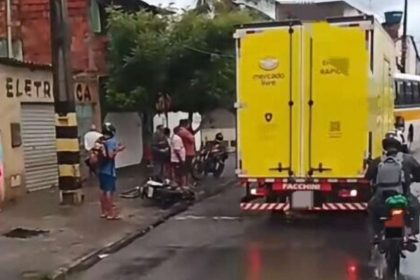 Isolamento da Polícia Militar com fita zebrada em trecho de avenida movimentada de Aracaju, com viatura do BPTran ao fundo.