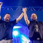 Foto de Bruno e Zezo no palco pegando nas mãos e levando ao alto