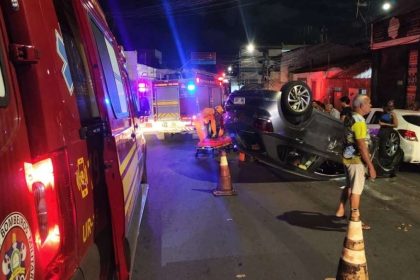Equipes de trânsito e socorro atuando à noite em via urbana do Centro com veículo capotado na pista.