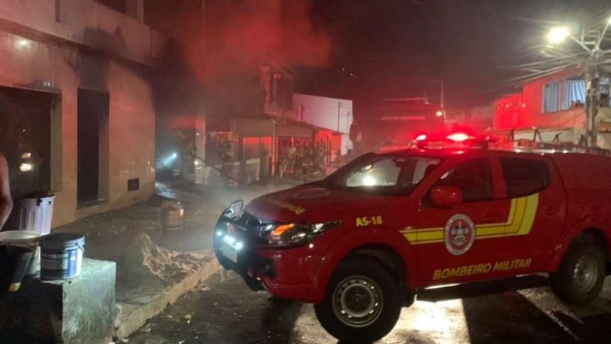 Equipes do Corpo de Bombeiros de Sergipe atuando com mangueiras e equipamentos de proteção no isolamento de uma área com fumaça.