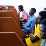 Estudantes universitários brasileiros reunidos em auditório durante palestra do ACNUR sobre combate às fake news e direitos humanos.