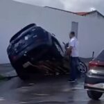 Veículo com as rodas presas em cratera formada na pista por conta do asfalto cedido.