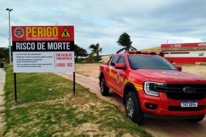 Placa vermelha de advertência do Corpo de Bombeiros em área de perigo na areia da Praia dos Artistas, em Aracaju.