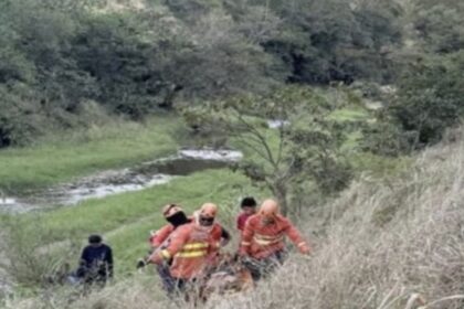 Equipe do Corpo de Bombeiros atuando em resgate em área de vegetação e pedras.