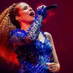 A cantora Vanessa da Mata em apresentação nos palcos com figurino de show.