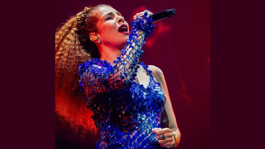 A cantora Vanessa da Mata em apresentação nos palcos com figurino de show.