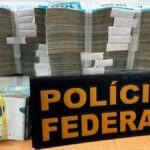 Notas de dinheiro em espécie e celular apreendidos pela Polícia Federal em Aracaju.