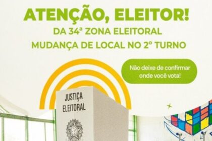 Eleitores consultando local de votação na entrada de uma escola da Justiça Eleitoral.